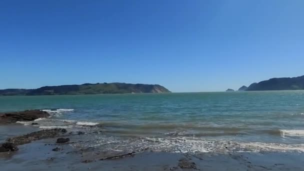 Άδεια αμμώδης παραλία με βράχια και νερά, παραλία, τουριστικός προορισμός, απόμακρη ακτογραμμή, Νέα Ζηλανδία, Auckland beach, οριζόντιος προσανατολισμός — Αρχείο Βίντεο