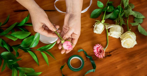 Blomsterhandler hænder holder en frisk blomst, hvilket gør en buket eller blomst arrangement, blomsterhandler master class eller værksted - Stock-foto