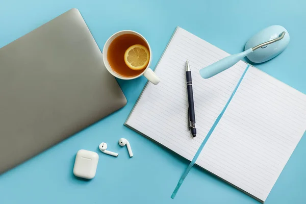 Negocios flatlay, trabajo desde casa, freelance, redacción, top view laptop, portátil con páginas en blanco y taza de té sobre fondo azul — Foto de Stock