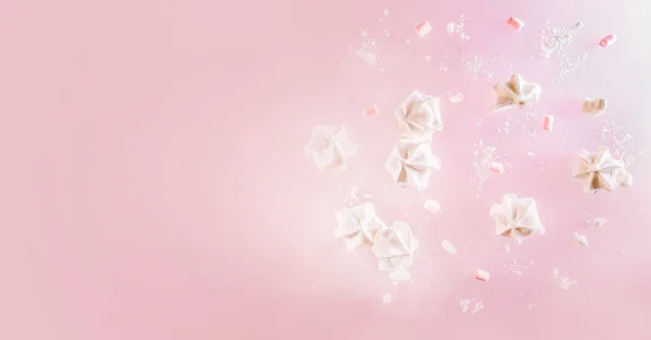 Witte meringue koekjes vliegen over roze achtergrond. Levitatie trend foto. Begrepen, ruimte. Zoet bak- en kookconcept — Stockfoto