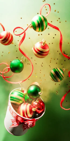 装飾されたバケツ、クリスマスのお祝いカード、新年の季節の挨拶はがきから飛んでくるクリスマスボールと装飾。浮遊写真の傾向の写真 — ストック写真
