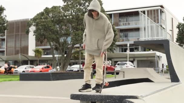 Tonårspojke i en skatepark, utomhusporträtt. tonårskoncept, tonårskultur — Stockvideo