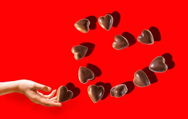 Рука Тримає Шоколадні Цукерки Формі Серця Роблячи Серце Ізольованим Яскраво — стокове фото