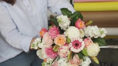 Küçük bir iş. Çiçekçide odaklanmış olmayan kadın çiçekçi. Çiçek tasarım stüdyosu, dekorasyon ve düzenlemeler. Çiçek teslimatı, düzen yaratmak. 