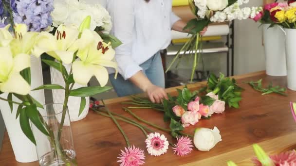 Klein bedrijf. Vrouwelijke bloemist zonder focus in de bloemenwinkel. Floral design studio, het maken van decoraties en arrangementen. Bloemen levering, het creëren van orde — Stockvideo