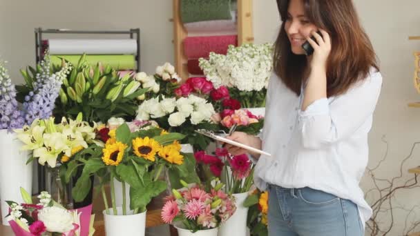 Piccole imprese. Fiorista femminile sfocata nel negozio di fiori. Studio di progettazione floreale, facendo decorazioni e arrangiamenti. Consegna fiori, creazione ordine — Video Stock