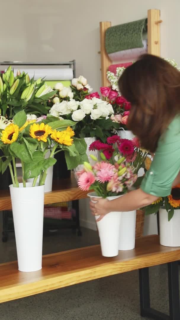 Piccole imprese. Fiorista femminile sfocata nel negozio di fiori. Studio di progettazione floreale, facendo decorazioni e arrangiamenti. Consegna fiori, creazione ordine — Video Stock