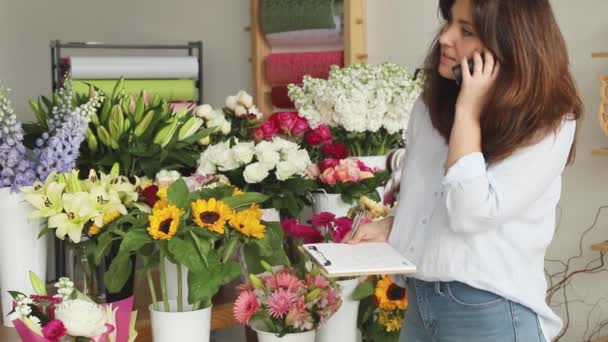 Kisvállalkozás. Női virágárus, aki nem koncentrál a virágüzletre. Virágos design stúdió, dekoráció és előkészületek. Virágok szállítási, létrehozása érdekében — Stock videók