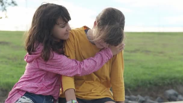 Dwie młode nastolatki czatujące na świeżym powietrzu, dziewczynki rozmawiające na naturalnym tle — Wideo stockowe