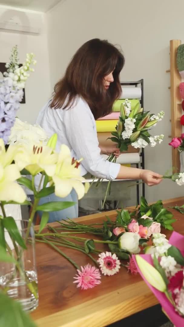 Piccole imprese. Fiorista femminile sfocata nel negozio di fiori. Studio di progettazione floreale, facendo decorazioni e arrangiamenti. Consegna fiori, creazione ordine — Video Stock