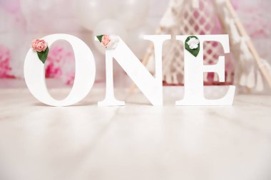 Birinci yaş günü pastası için pembe ve beyaz süsleme balonlarla, kağıt dekorlarla, pasta ve süslemelerle stüdyo fotoğraf çekimi.