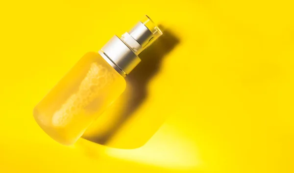将透明瓶子喷在黄色背景 化妆品或护肤产品上 高质量的照片 — 图库照片