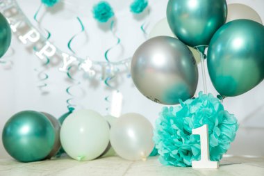 sliver, blue and white decoration for a 1st birthday cake smash studio photo shoot with balloons, paper decor, cake and topper. High quality photo