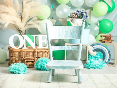 sliver, blue and white decoration for a 1st birthday cake smash studio photo shoot with balloons, paper decor, cake and topper. High quality photo