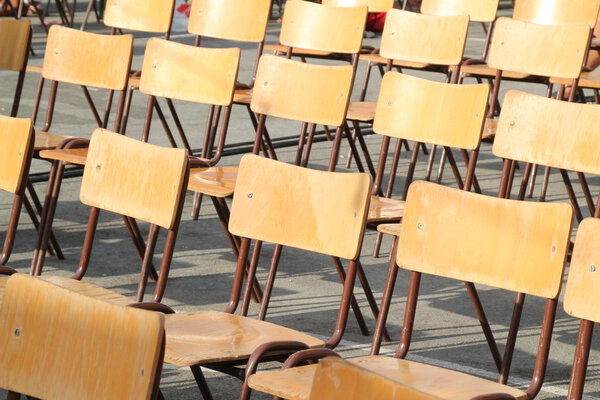 Wooden chairs aligned at outdoor school event