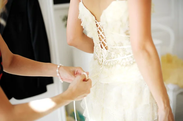 Dama de honra ajudando noiva a se vestir — Fotografia de Stock