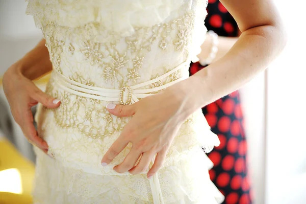 Demoiselle d'honneur aider mariée à s'habiller — Photo