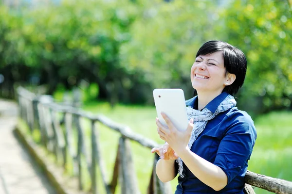 Smiling caucasian woman using tablet computer — Stock Photo, Image