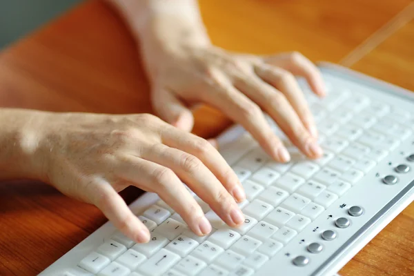 Mãos femininas digitando em um teclado pc — Fotografia de Stock