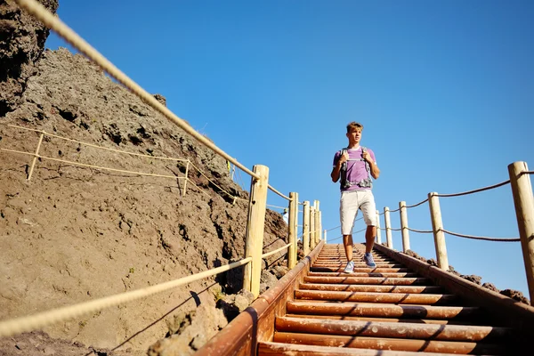 Чоловік ходить по дерев'яних сходах по скелястій стежці — стокове фото