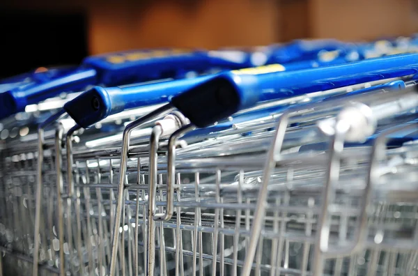 Rij van metaal winkelen karren in een supermarkt — Stockfoto