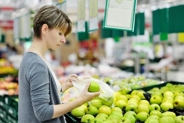 Alma, gyümölcs szupermarketben kiválasztása nő — Stock Fotó