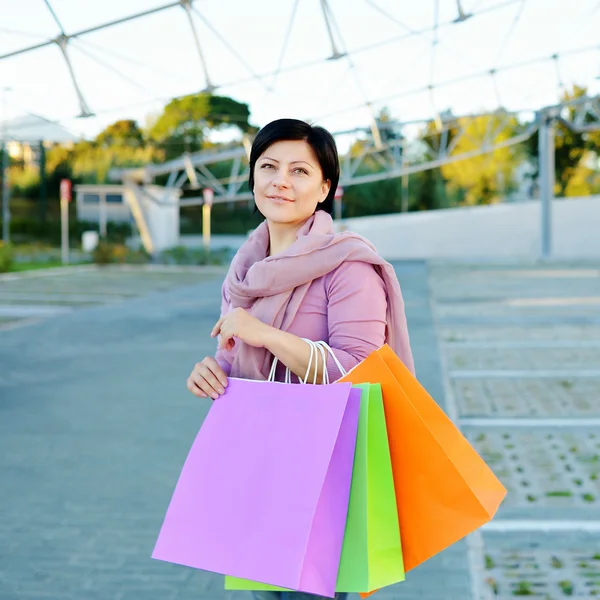 Женщина держит цветные бумажные пакеты для покупок — стоковое фото