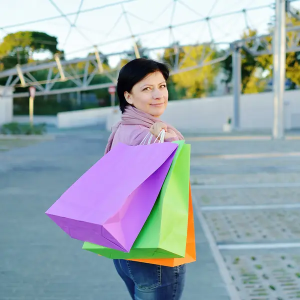 Kobieta z kolorowego papieru torby na zakupy w ręku — Zdjęcie stockowe