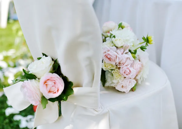 Hermoso ramo de boda en una silla blanca — Foto de Stock