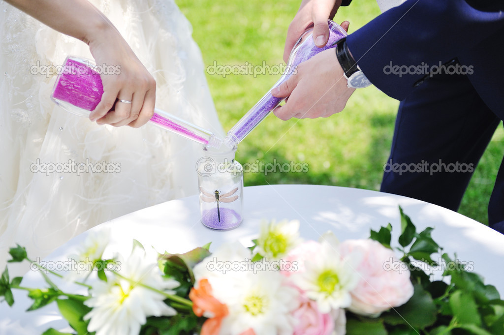bride and groom doing sand ceremony during wedding