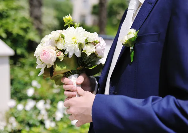 Groom hands holding wedding bouquet — Stock Photo, Image