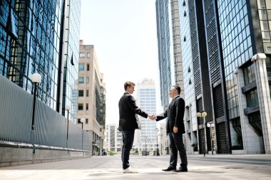 arka ofis kurumsal binalar üzerinde el sıkışan iki iş adamları