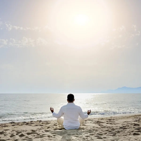 Uomo che pratica esercizi di meditazione yoga sulla spiaggia - concetto di stile di vita sano — Foto Stock