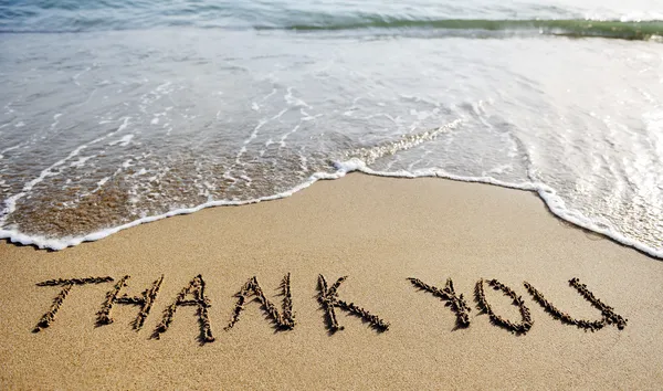 Danke Wort auf den Sand am Strand gezeichnet — Stockfoto