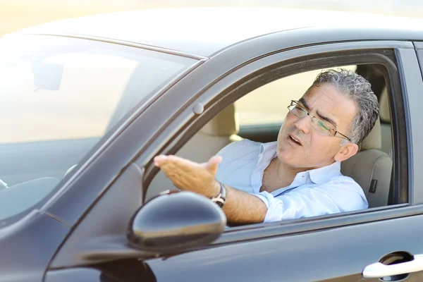 irritated male driving car in traffic - road rage concept