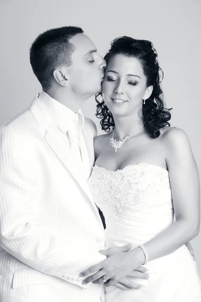 Bräutigam küsst die Braut im Studio — Stockfoto