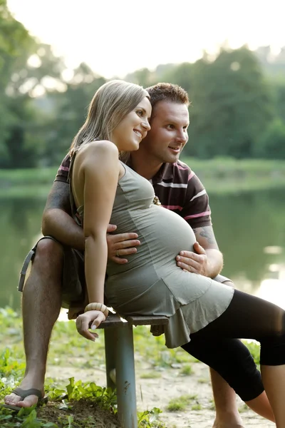 他的丈夫在美丽的晴天在公园的幸福怀孕女人 — 图库照片