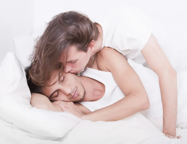 Гей-пара целуется на кровати Лицензионные Стоковые Фото