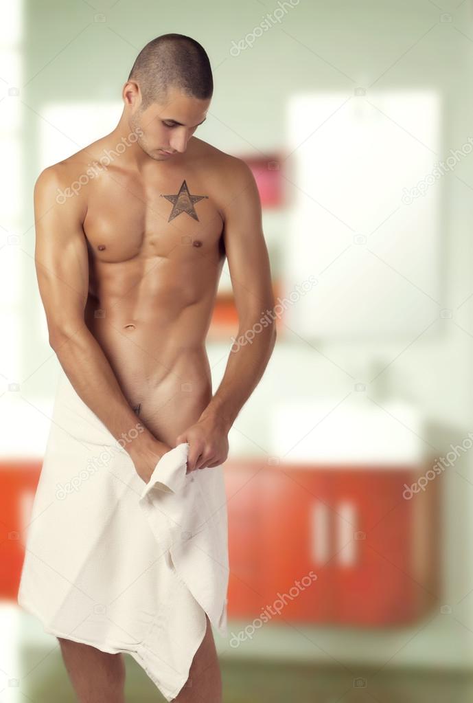 Young man with a towel stepping out of the bathtub