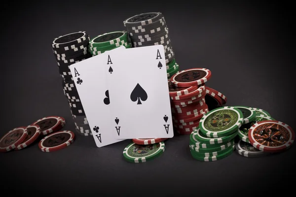 Two aces with chips on dark background — Stock Photo, Image