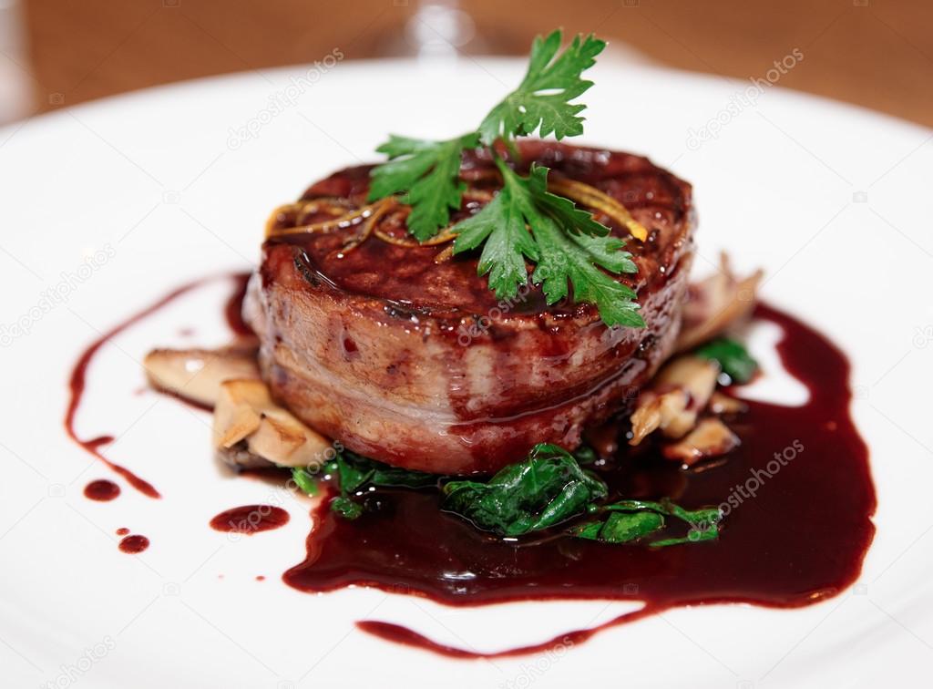Tenderloin steak wrapped in bacon with red sauce — Stock Photo