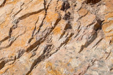 Çiğ, sarı, kahverengi granit kaplama arka plan. Doğal kaya dokusu arka planı. Granit Notlar. Moskovalı renkli granit mineraller