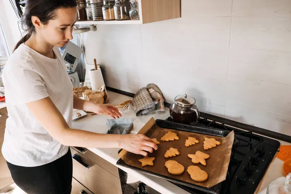 Kvinna kokar pepparkakor. Julen hemlagad pepparkaka kex på bakning pan på hemkök. Matlagning hemma, pepparkakstillverkning process — Stockfoto