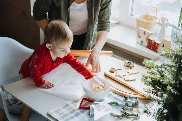 Gemütliche Weihnachten zu Hause. Familienvorbereitung Urlaubsdessert. Mutter und kleine Tochter spielen mit Mehl, machen Teig und kochen gemeinsam Lebkuchen in der heimischen Küche. — Stockfoto