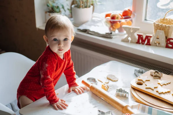 Мила маленька дівчинка малюка робить різдвяне печиво на домашній кухні і грає з тістом. Мама і маленька дівчинка випікають різдвяні пряники для сімейної вечері напередодні Різдва . — стокове фото