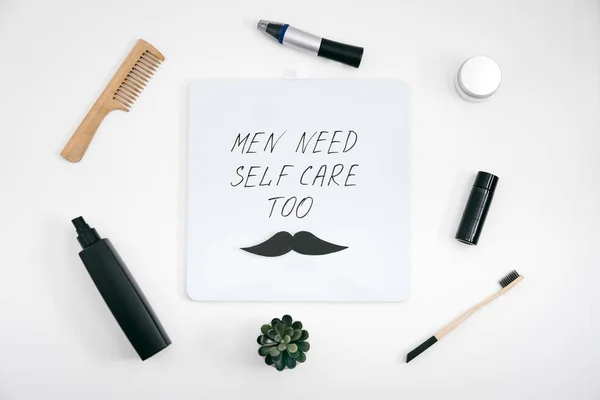 男人的自我护理工具包，带有男性美容产品和装置，以及带有文字的书信板。男人也需要自我护理。男人自我护理装置，为男友、丈夫和父亲配备护肤护发产品 — 图库照片