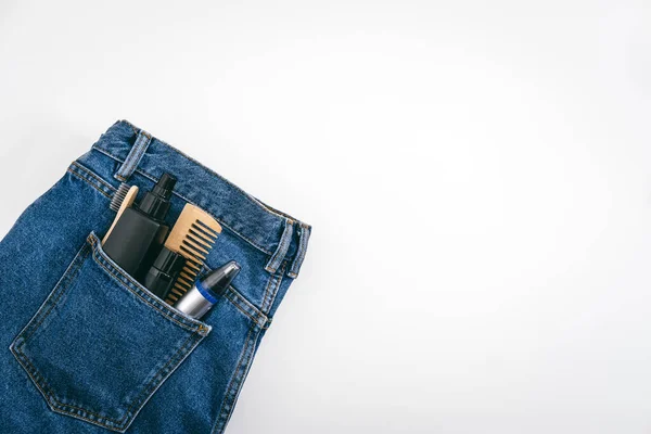 Homens kit de beleza auto-cuidado, produtos cosméticos cuidados de beleza masculina e dispositivos no bolso jeans jeans azul jeans. Auto-cuidado homem definido com produtos de cuidados com a pele e cabelo. — Fotografia de Stock