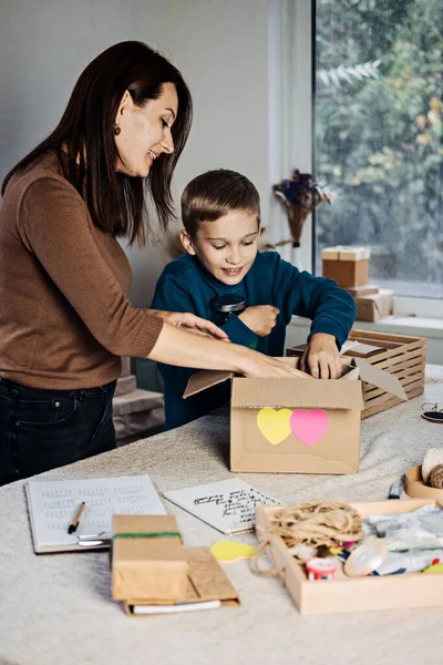 Charity Care box, donation box, gift package ideas. Happy family, mother, kid and dog putting staff into donation box. Care Package Delivery, Winter holidays Food Care gift box — Stockfoto