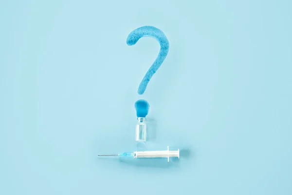Covid 19 vaccine side effects. Vaccine Storage and Handling. Spilled medicine vial bottle, question mark and syringe on blue background.