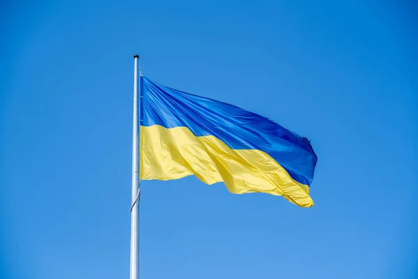 stock image Ukrainian flag in the wind on blue sky background. Large national yellow blue flag of Ukraine. Big Ukrainian state banner.